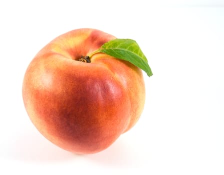 Ripe nectarine with green leaf on white background