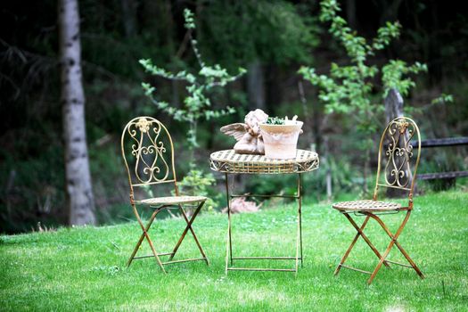 romantic garden patio with two chairs, a table and table decorations