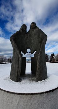 Religious statue symbolizing family. Cross in the back