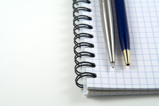 Two pens on spiral notebook with copyspase for your text