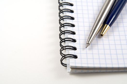 Two pens on spiral notebook with copyspase for your text