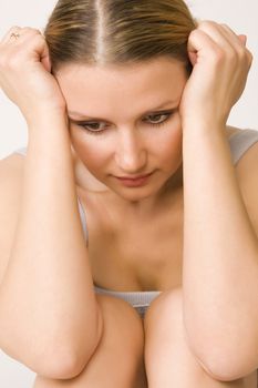 Portrait of young beautiful sad woman on white background