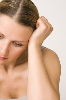 Portrait of young beautiful sad woman on white background