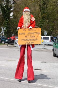 Anti-nuclear power protest at Krümmel Nuclear Power Station in Geesthacht, near Hamburg, Germany. 24th April 2010. Protester dressed as St. Claus, saying "I want to celebrate christmas with you without nuclear energy".