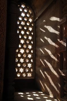 The sun shining through the ornately carved stone window inside the Alai Darwaza. The Alai Darwaza was built in 1311 to serve as the southern entrance to the Qutab Minar, one of the largest standing stone minarets in the world.