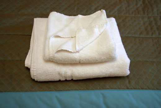 guest towels folded on the end of a bed