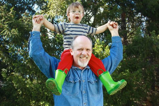 Father with son on shoulders and trees in background