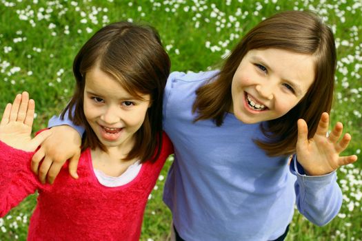 Two sisters waving