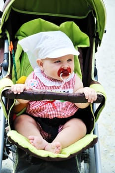 lovely baby girl sitting in the stroller
