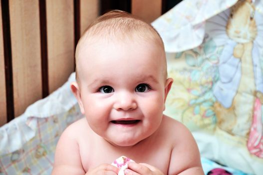 little lovely baby sitting in her bed
