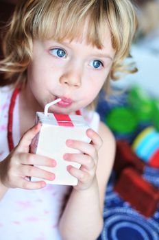  little lovely girl drinking juice from straw