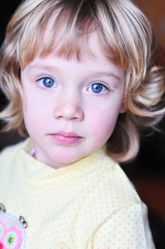Portrait of lovely little blonde girl with blue eyes