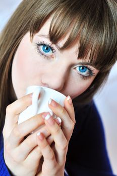 lovely girl is drinking something from white cup