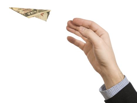 A man's hand throwing a paper plane made of a ten dollar bill.