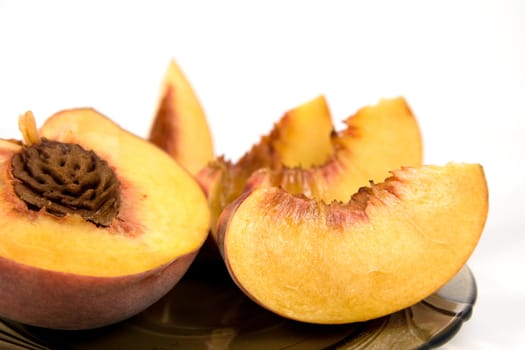 Macro short of half of peach and slices on plate