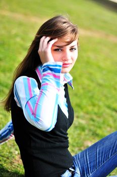 beautiful teen girl sitting on the grass