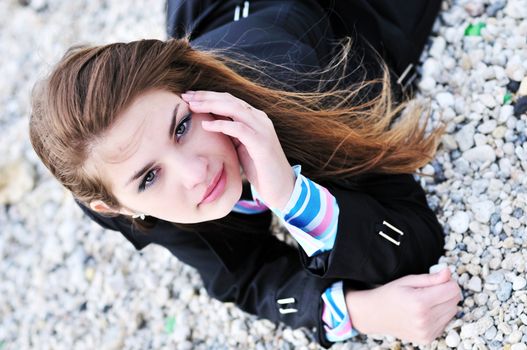 girl laying on the beach's  pebble