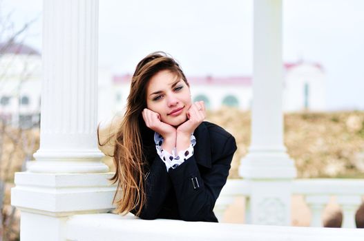 lovely sweet teen  girl standing  near columns