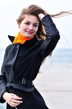 lovely teen girl in windy weather near the sea