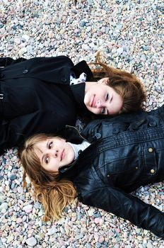 two teen girls laying on the pebble in spring time