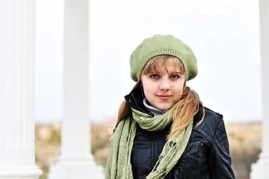 teen girl wearing beret standing near the columns