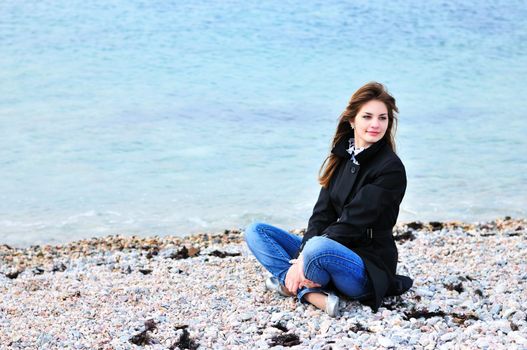 sweet girl relaxing on the beach in spring time