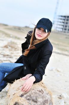 teen lovely girl on the beach , she is wearing cap
