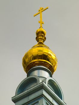 A golden dome with a cross of christian temple