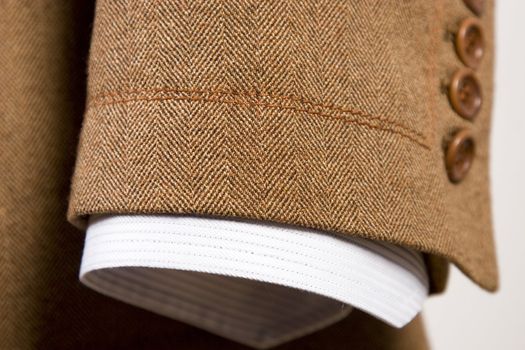 closeup of suit, detail of brown cuff and white shirt