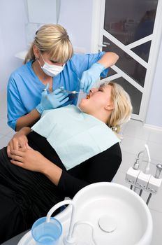 female dentist works with patient the office