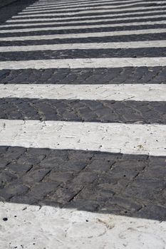 Detail of zebra striped pedestrian walk on cobblestone street