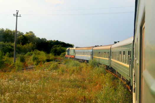 Eastern european train entering into a forested area of track
