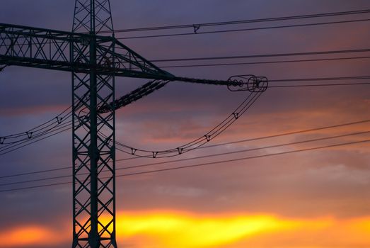 Electricity pylon silhouette in the evening sunset sky.