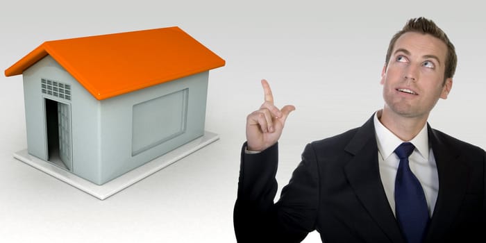 business man gesturing with hand and three dimensional house on isolated white background