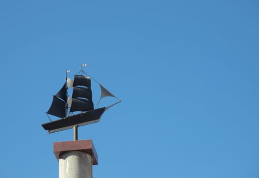Sculpture of the ship on a background of the dark blue sky    
