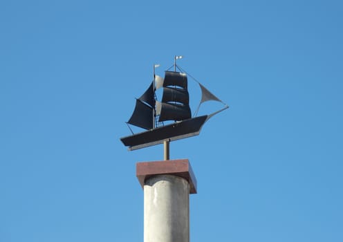 Sculpture of the ship on a background of the dark blue sky