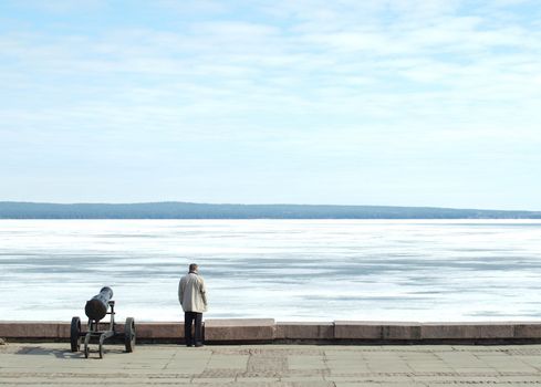The man and a gun on coast of lake. Quay of Petrozavodsk, Russia     
