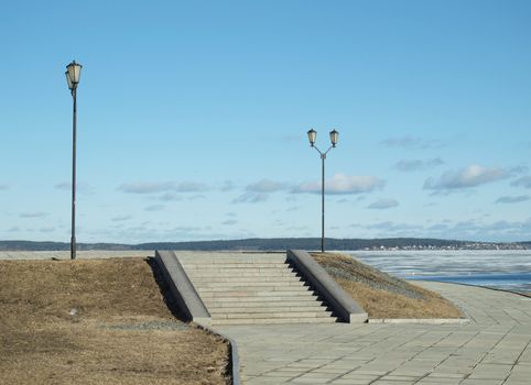Two lanterns and ladder on quay of Petrozavodsk in the spring, Russia
