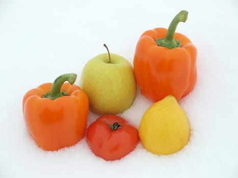 Lemon, pepper, apple and tomato on a snow    