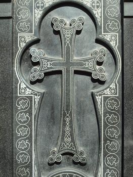 Cross on a black granite wall   