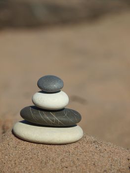 Black, white and grey pebble on sand on coast of lake          