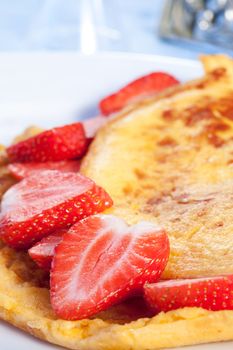 Omelette with sliced fresh strawberries on plate