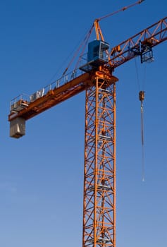 Construction crane against the blue cloudless sky