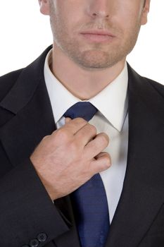 young businessman fastening his tie on white background