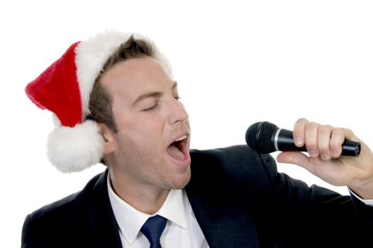 young man singing into microphone with santa cap on an isolated background