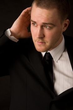 Portrait of a young businessman on black background