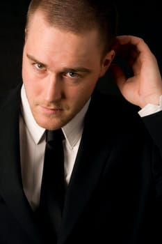 Portrait of a young businessman on black background