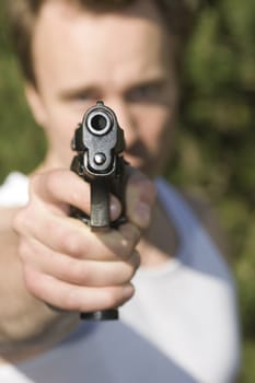A man holding a gun and pointing it at the camera.
