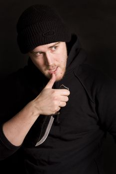 evil criminal with a knife wearing balaclava