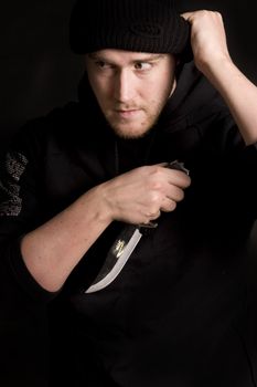 evil criminal with a knife wearing balaclava